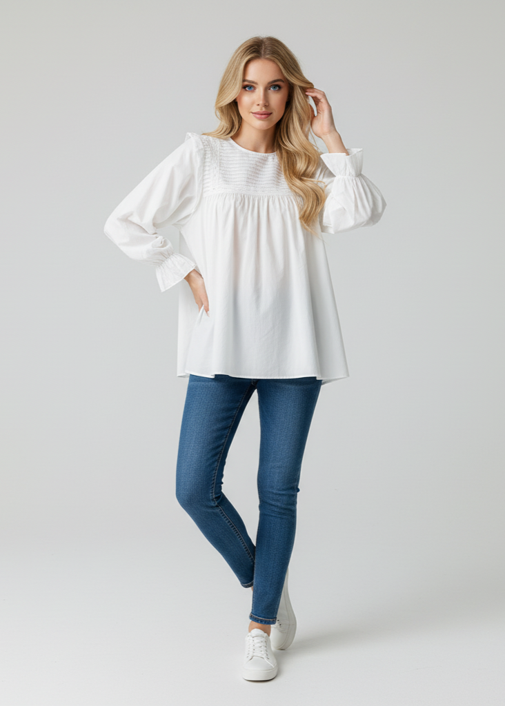 Woman wearing a white blouse and blue jeans on a plain background