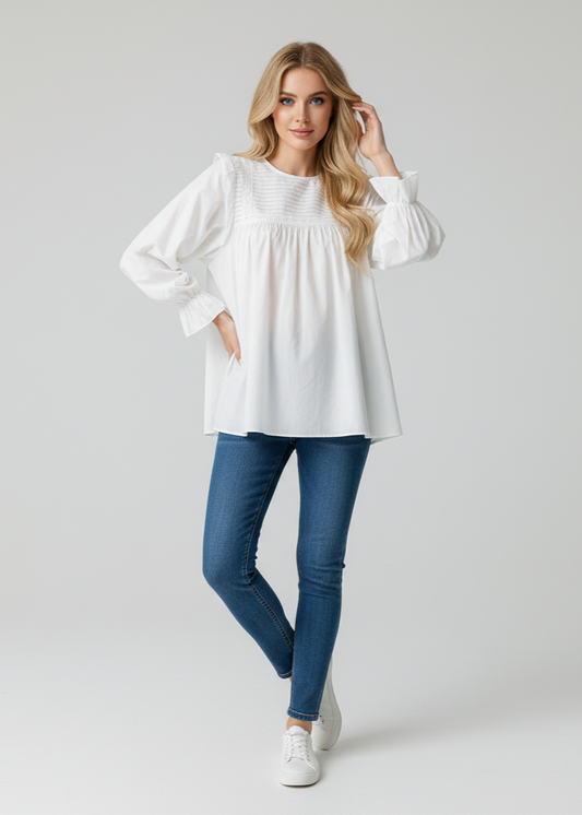 Woman wearing a white blouse and blue jeans on a plain background