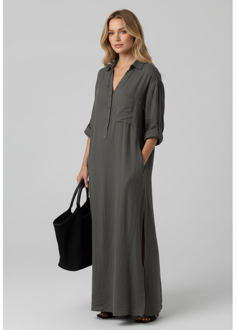 Woman wearing a long gray dress holding a black bag on a gray background