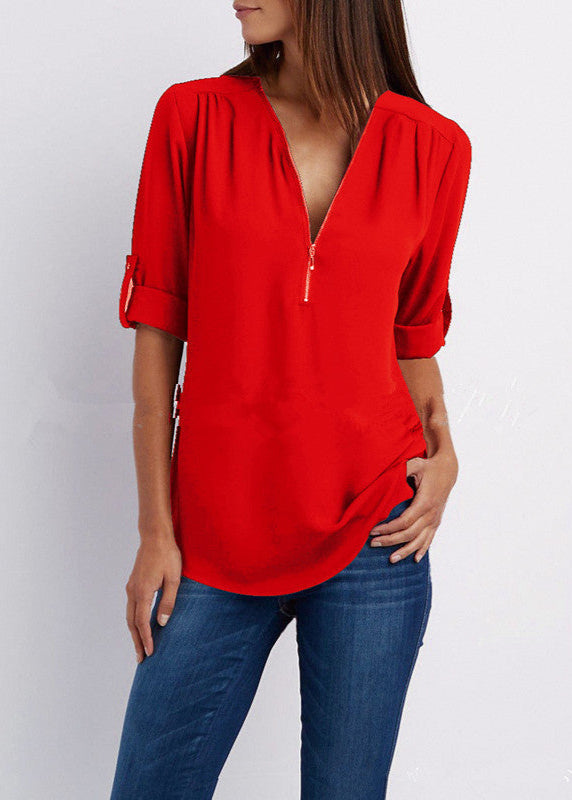 Red blouse with a deep neckline worn by a person on a white background