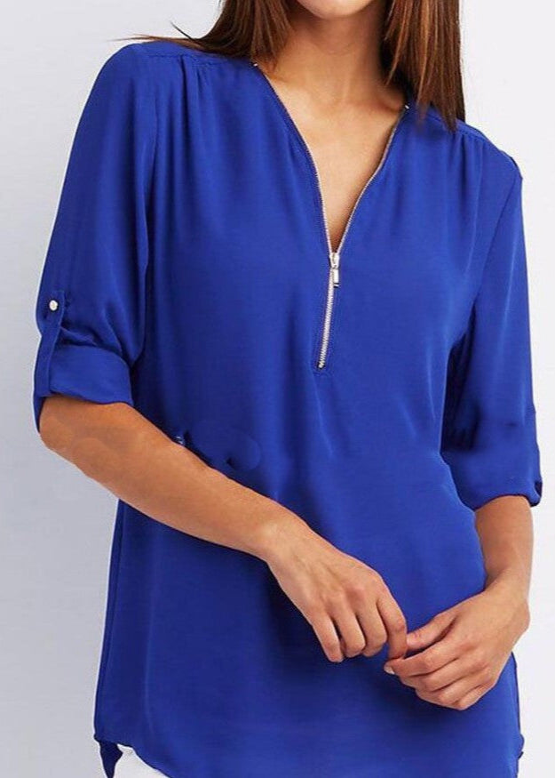 Blue blouse with a zipper detail on a plain background