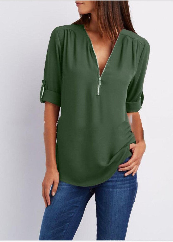 Green blouse with a V-neck and short sleeves worn by a person on a white background