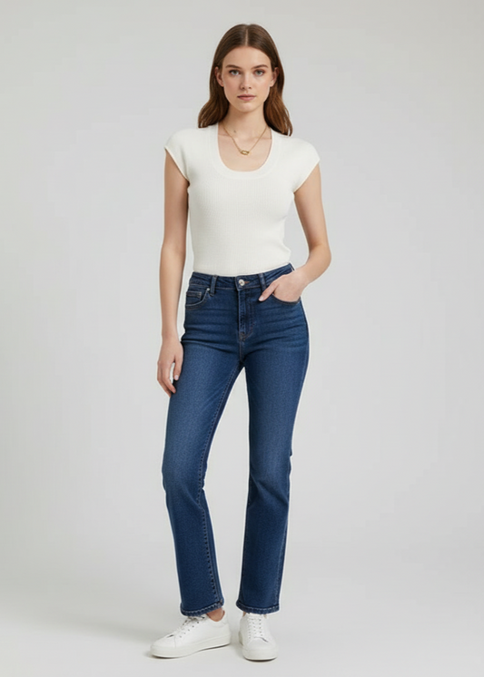 Woman wearing a white top and blue jeans on a plain background