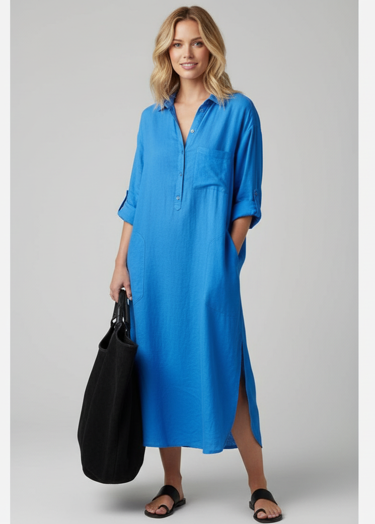 Woman wearing a blue dress holding a black bag on a gray background