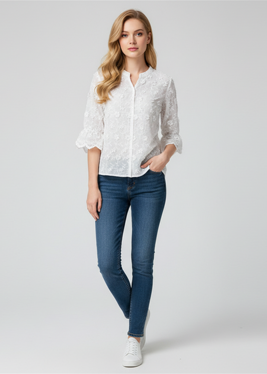 Woman wearing a white lace blouse and blue jeans on a gray background